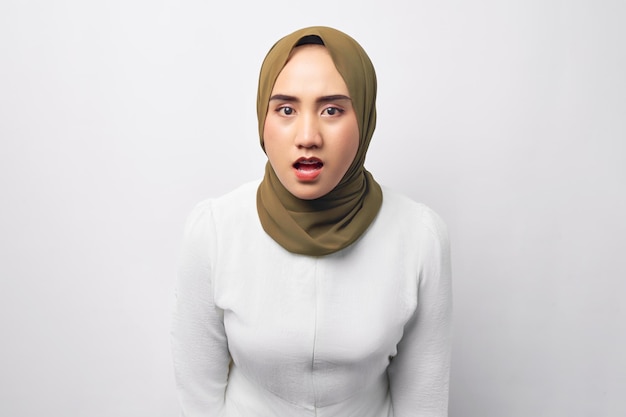 Choqué jeune belle femme musulmane asiatique des années 20 portant le hijab en regardant la caméra avec la bouche ouverte isolée sur fond blanc Concept de style de vie religieux des gens