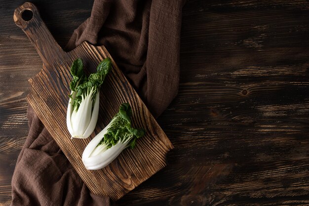 Chou bok choy feuillu sur une planche à découper, légumes verts sains.