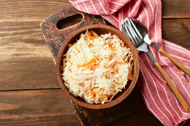 Chou fermenté choucroute aux carottes dans un bol sur fond de bois Superfoods pour soutenir le système immunitaire Vue de dessus à plat