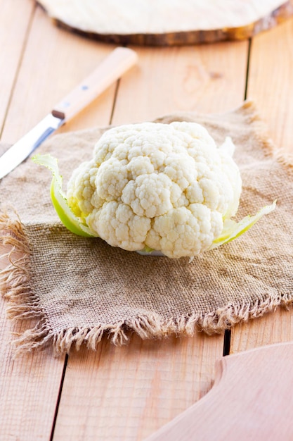 Photo le chou-fleur biologique sur fond de bois la tête du chou-flor sur le burlap la nourriture végétarienne