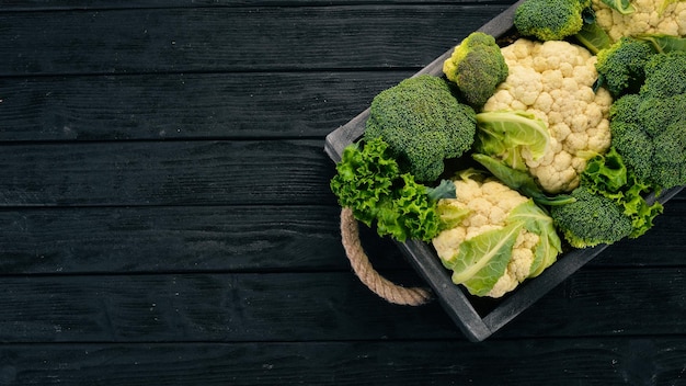 Chou-fleur et brocoli dans une boîte en bois Légumes frais Sur un fond en bois Vue de dessus Espace de copie