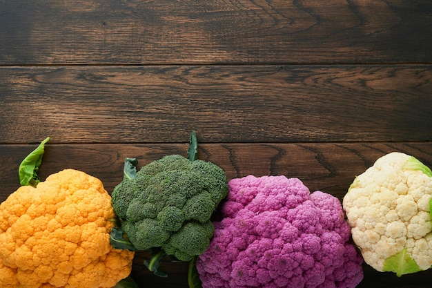 Chou-fleur coloré Diverses sortes de chou-fleur sur fond de bois ancien Choux de couleur violet jaune blanc et vert Brocoli et Romanesco Récolte agricole Maquette