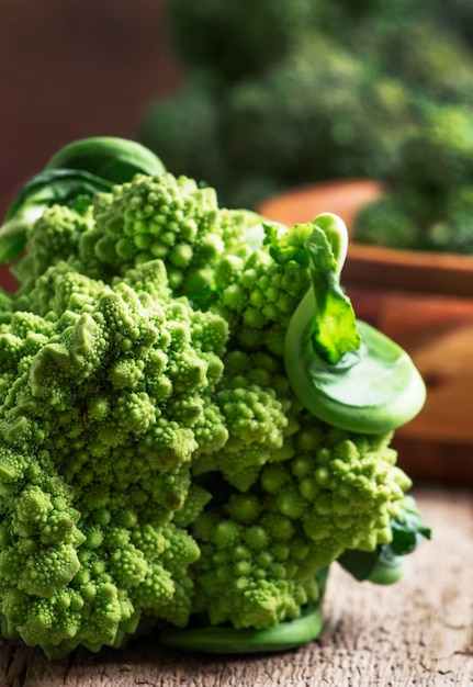 Chou-fleur romanesco vert vieux fond de table de cuisine en bois mise au point sélective