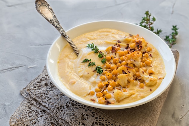 Chou-fleur rôti frais et soupe de pois chiches dans un bol sur béton gris clair