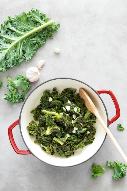 Chou frisé sauté à l'ail dans une poêle en fonte sur la table de cuisine concept d'aliments sains superfood