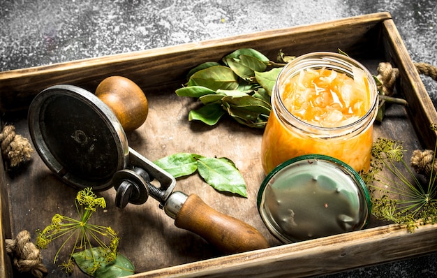 Chou mariné aux herbes et sertisseur sur un plateau.