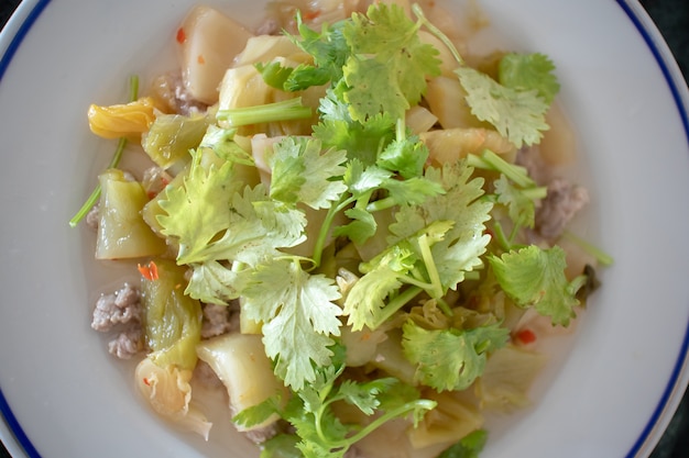 Chou mariné épicé sur un plat blanc pour le riz de la bouillie thaïlandaise.