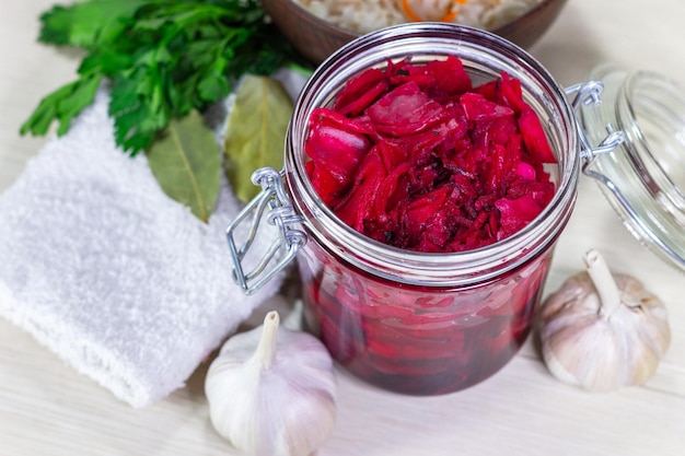 Choucroute de chou en conserve fermentée saine avec betteraves et herbes dans une vue de dessus de bocal en verre.