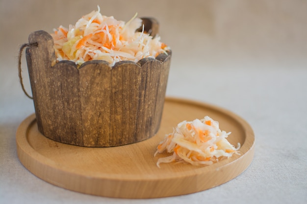 Choucroute dans un tonneau en bois sur un support rond en bois. Choucroute maison aux carottes. Aliments fermentés.