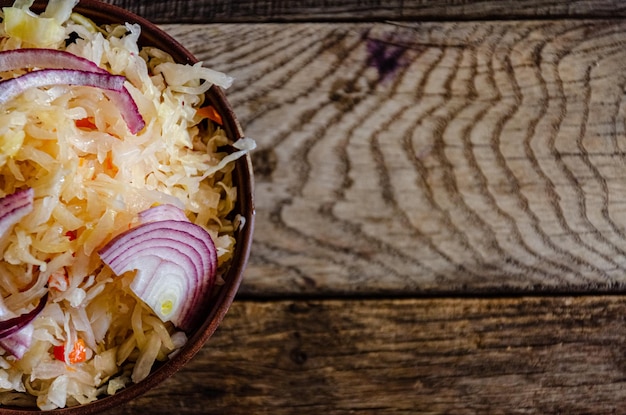 Choucroute en faïence sur fond de bois. Cuisiner des aliments fermentés maison.