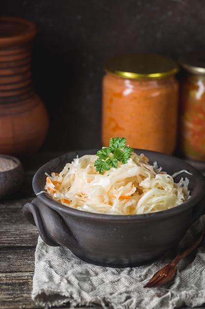 Choucroute maison avec carottes dans un bol sur table rustique en bois. Nourriture végétalienne végétarienne.