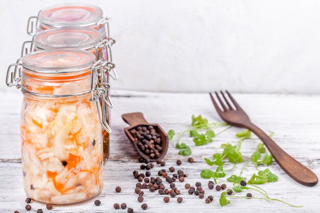 Choucroute maison marinée aigre en table de cuisine en bois rustique de bocaux en verre