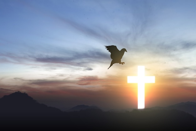 Christian Cross et silhouette de pigeon avec un ciel au lever du soleil