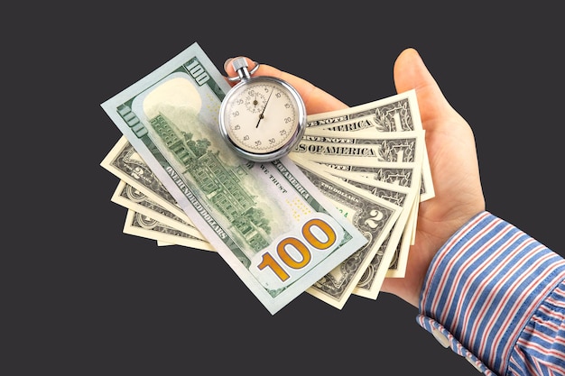 Chronomètre mécanique et dollars dans la main de l'homme Précision à temps partiel pour les affaires et les finances