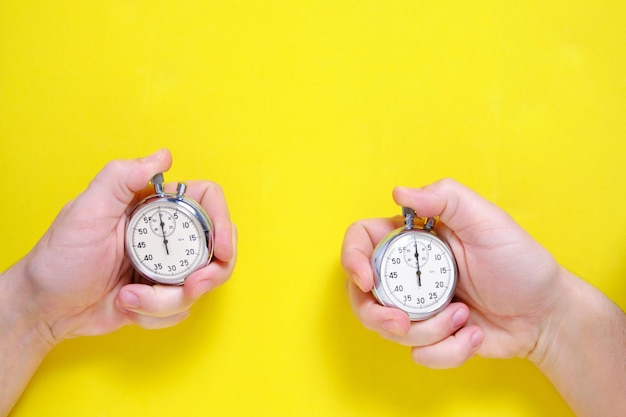 Chronomètres mécaniques à deux aiguilles sur fond jaune.