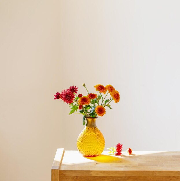 Chrysanthèmes dans un vase en verre sur fond blanc