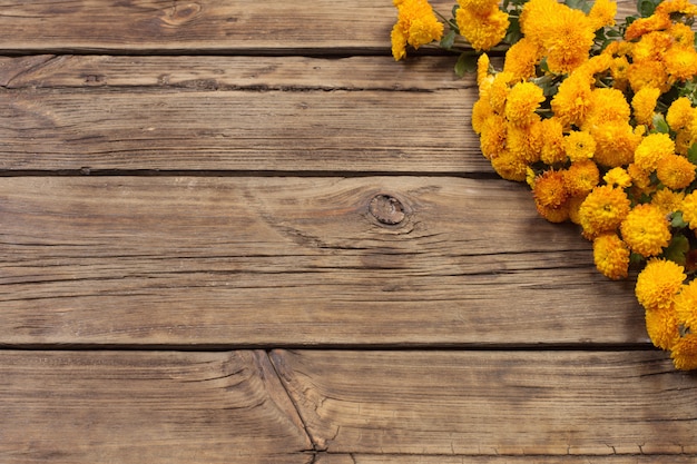 Chrysanthèmes orange sur fond de bois ancien