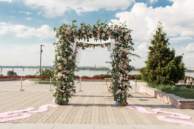 Un chuppah festif décoré de fleurs fraîches pour une cérémonie de mariage en plein air
