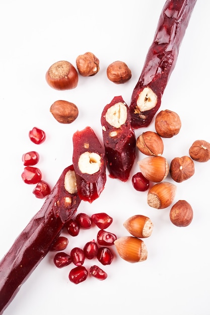 Churchkhela à base de jus de grenade et de noix, bonbons traditionnels géorgiens isolés sur fond blanc avec espace de copie