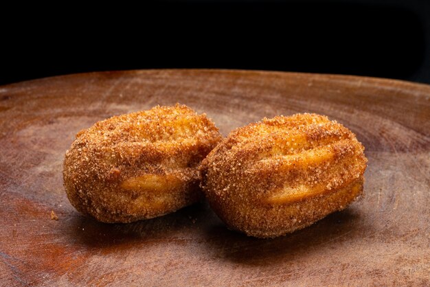 Churros au dulce de leche servis sur une table en bois rustique.