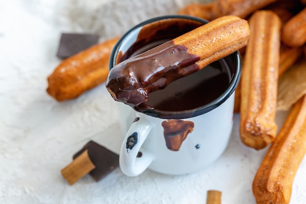 Churros à la cannelle dans une tasse de chocolat chaud