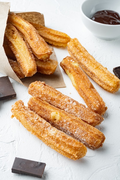 Churros dessert espagnol traditionnel avec du sucre et du chocolat, sur fond blanc