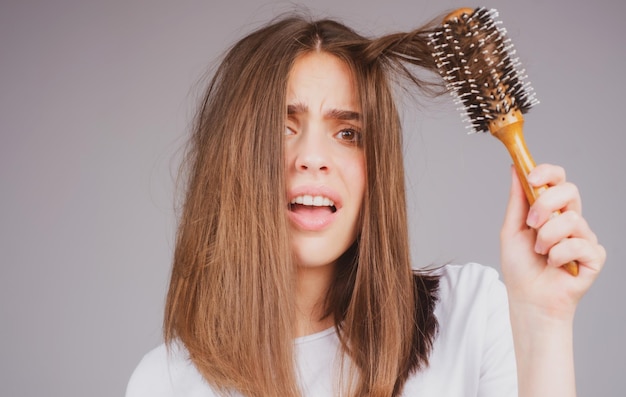 Chute de cheveux de perte de cheveux de plan rapproché dans le problème d'effort de brosse à cheveux de la femme avec un peigne