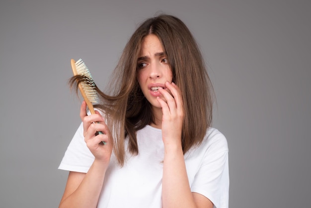 Chute de cheveux de perte de cheveux de plan rapproché dans le problème d'effort de brosse à cheveux de la femme avec un peigne