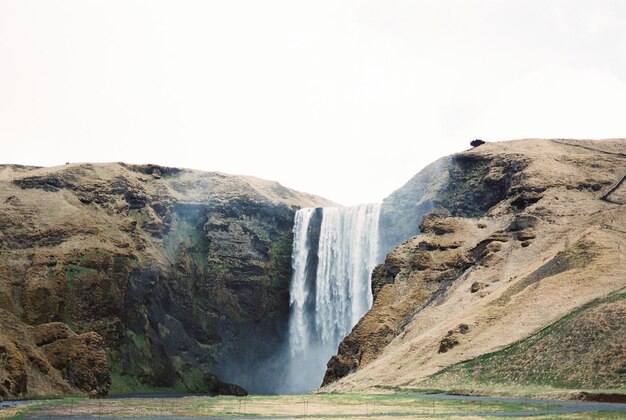 Chute d'eau dans les montagnes rocheuses au-dessus de la vallée de l'Islande