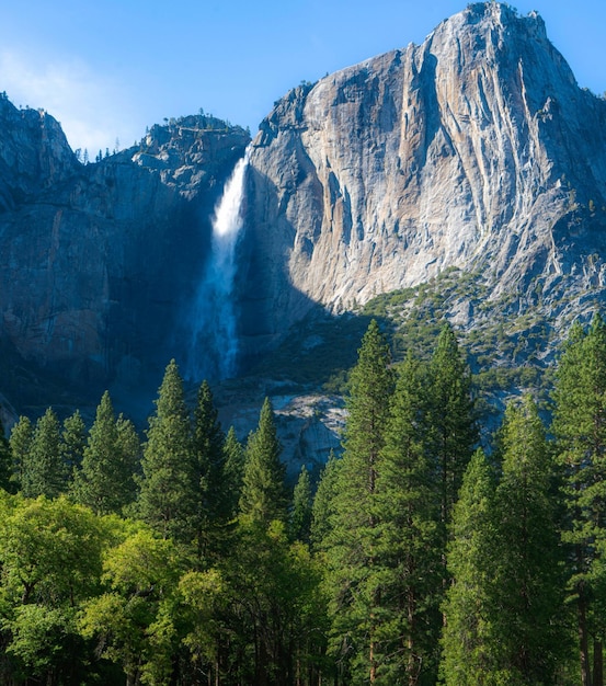 Une chute d'eau est visible devant une montagne.