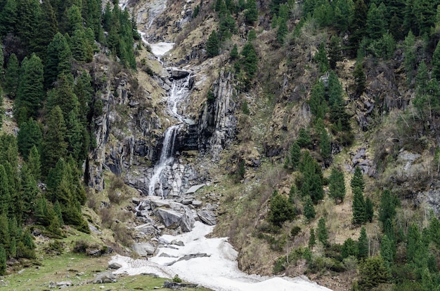 Chute d'eau avec de la neige sur la montagne