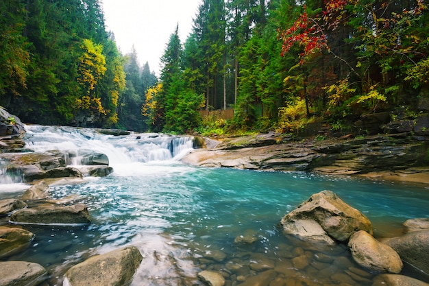 Photo chute d'eau sur la rivière de montagne avec de l'eau bleue