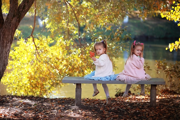 Chute des feuilles dans le parc. Enfants pour une promenade dans le parc en automne. Famille. Tomber. Joie.