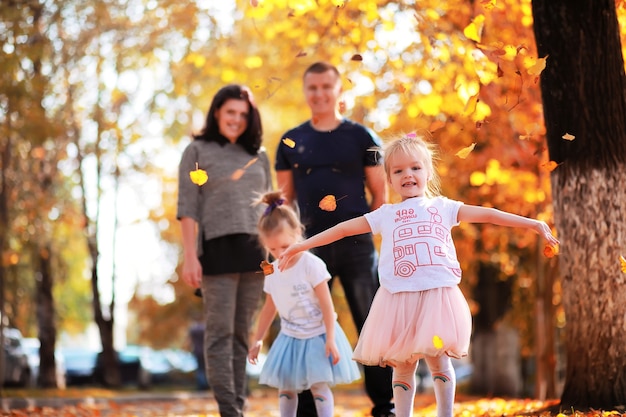 Chute des feuilles dans le parc. Enfants pour une promenade dans le parc en automne. Famille. Tomber. Joie.