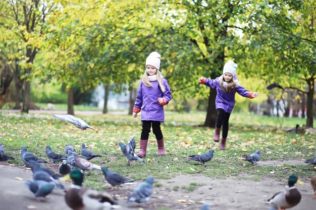 Chute des feuilles dans le parc. Enfants pour une promenade dans le parc en automne. Famille. Tomber. Joie.