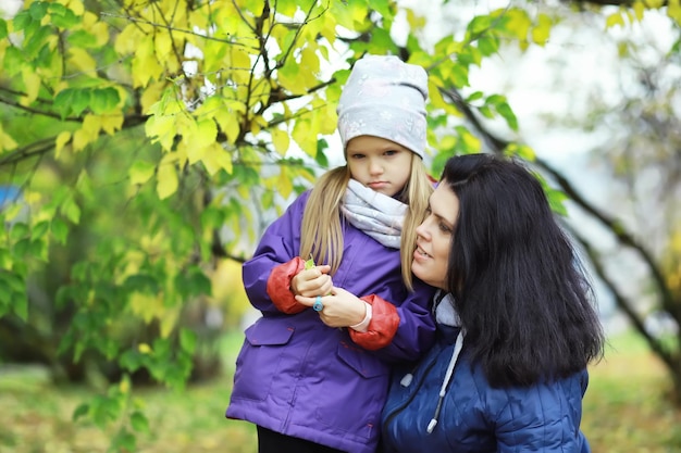 Chute des feuilles dans le parc. Enfants pour une promenade dans le parc en automne. Famille. Tomber. Joie.