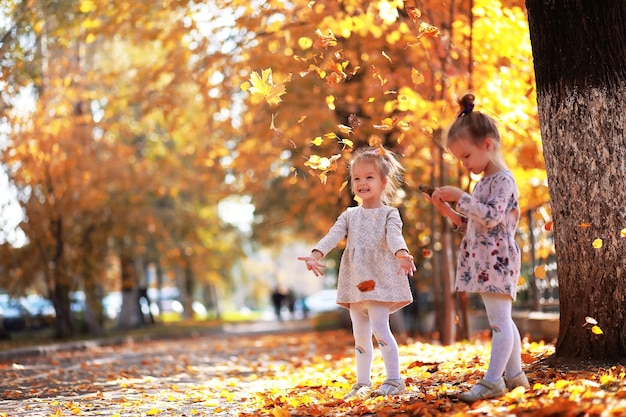 Chute des feuilles dans le parc. Enfants pour une promenade dans le parc en automne. Famille. Tomber. Joie.