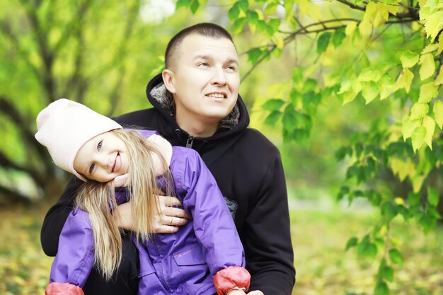 Chute des feuilles dans le parc. Enfants pour une promenade dans le parc en automne. Famille. Tomber. Joie.