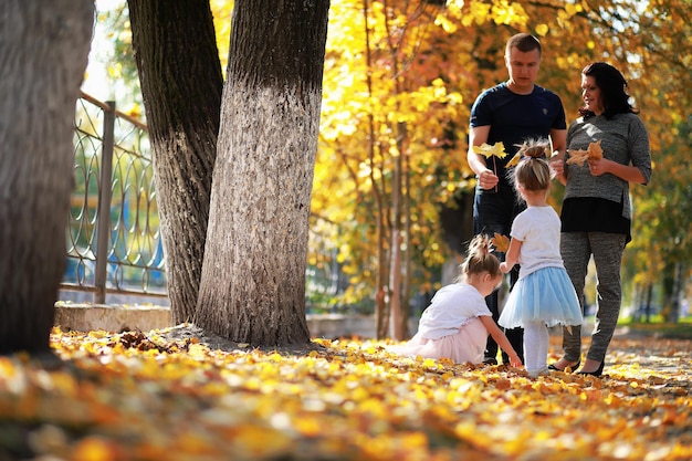 Chute des feuilles dans le parc. Enfants pour une promenade dans le parc en automne. Famille. Tomber. Joie.