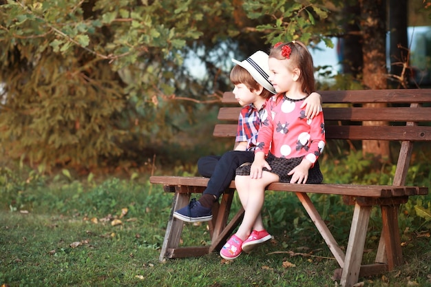 Chute de feuilles dans le parc Enfants se promenant dans le parc d'automne Bonheur d'automne en famille