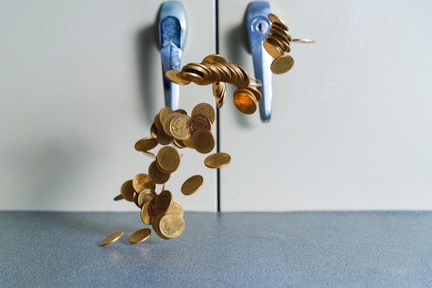 Chute de pièces d&#39;or en argent sur la table de bureau avec fond armoire à document