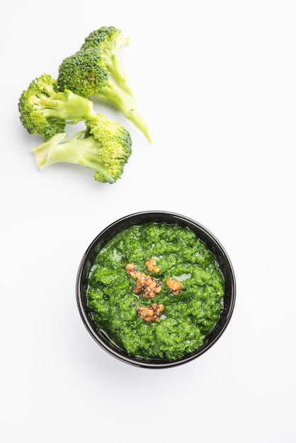 Chutney de brocoli frais ou purée de pâte dans le bol avec des morceaux crus