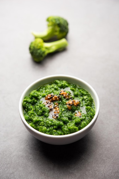 Chutney de brocoli frais ou purée de pâte dans le bol avec des morceaux crus