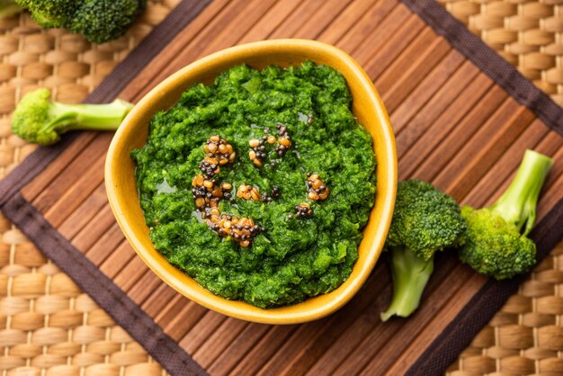 Chutney de brocoli frais ou purée de pâte dans le bol avec des morceaux crus