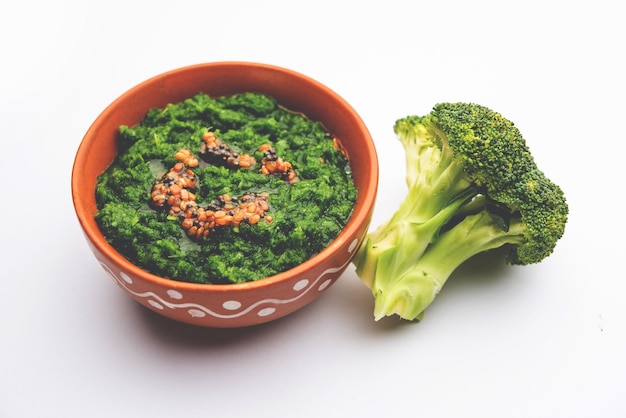 Chutney de brocoli frais ou purée de pâte dans le bol avec des morceaux crus