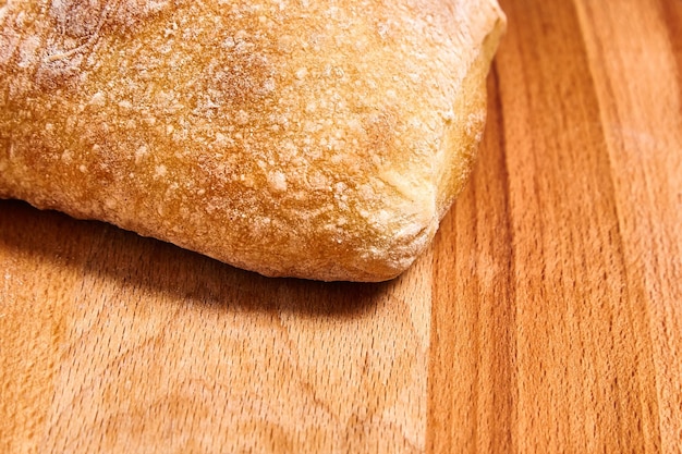 Ciabatta, pain de blé italien traditionnel cuit avec de l'huile d'olive sur une surface en bois