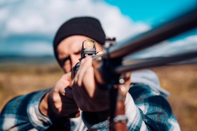 Photo cible de chasseur avec viseur laser viseur collimateur chasseur avec fusil de chasse en chasse cible de chasseur avec viseur laser chasseur visant le fusil dans la forêt braconnier dans la forêt