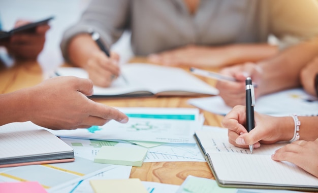 Cibler la recherche sur le public et les mains avec un cahier de papier marketing et le poster sur un bureau ou une table Collaboration de travail d'équipe en gros plan et stratégie de marque lors de l'écriture de publicité dans les médias