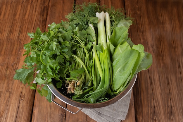 Ciboulette fraîche, aneth, persil, coriandre et oseille sur un fond en bois