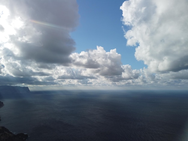 Ciel aéré abstrait avec des nuages dodus en mouvement au-dessus de la mer océan Petites vagues sur la surface de l'eau claire lumières bokeh du lever du soleil Vacances de vacances et concept récréatif